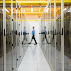 Technician walking in hallway of server room